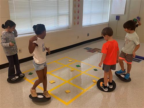 4 stuents balancing on ball discs